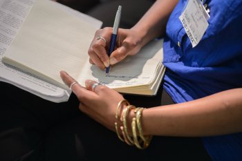 Hand mit Buch und Stift